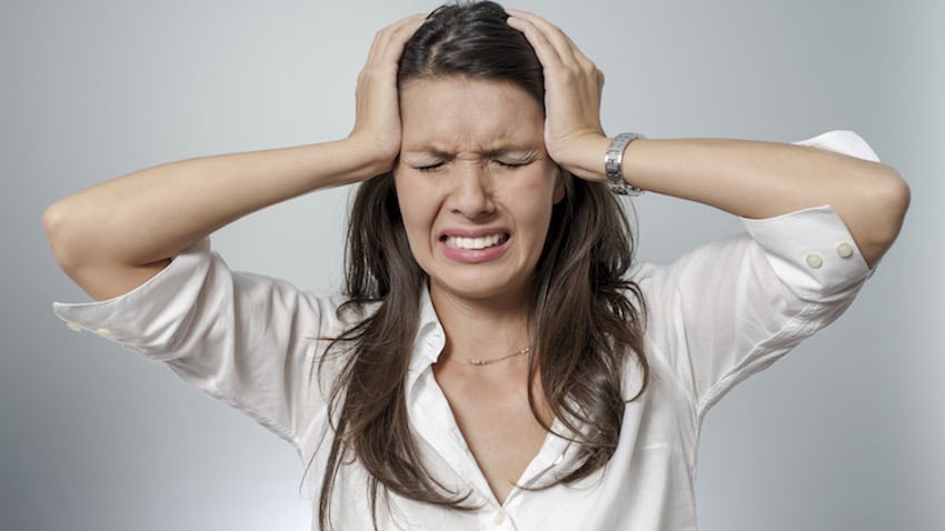 Mujer con dolor de cabeza intenso, representando una migraña severa.